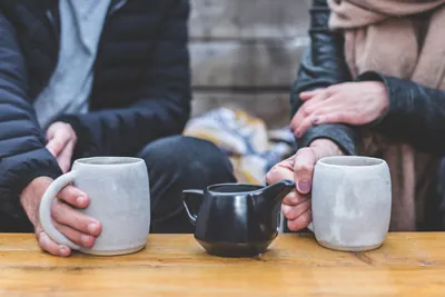 A couple on a date sitting at a table drinking tea